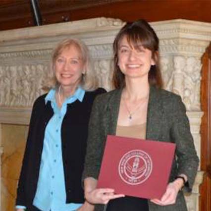 female student holding certificate and smiling for photo with woman next to her
