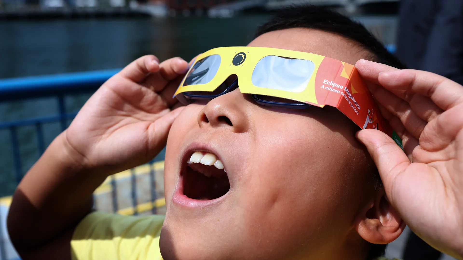 Child viewing eclipse with glasses.